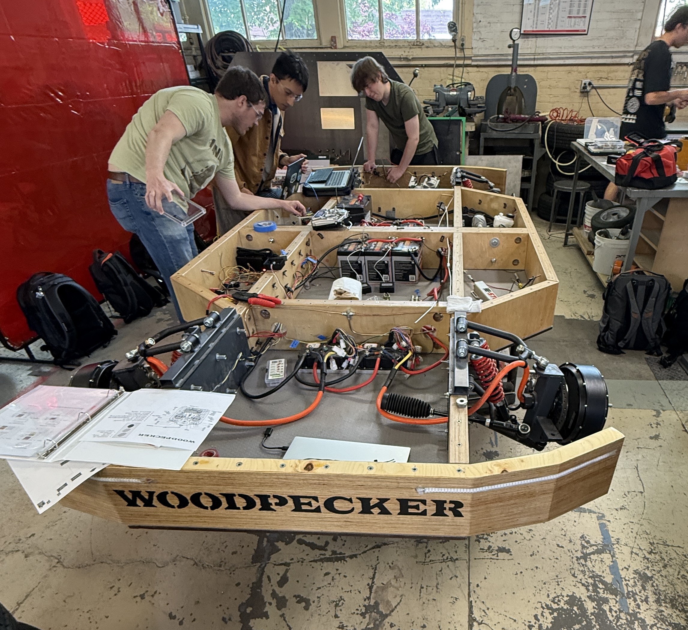 Team working on the Woodpecker autonomous EV platform in the shop